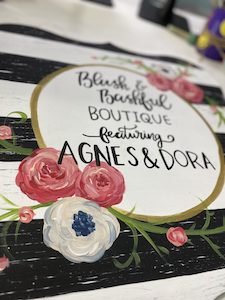 boutique sign with floral and stripe patterns