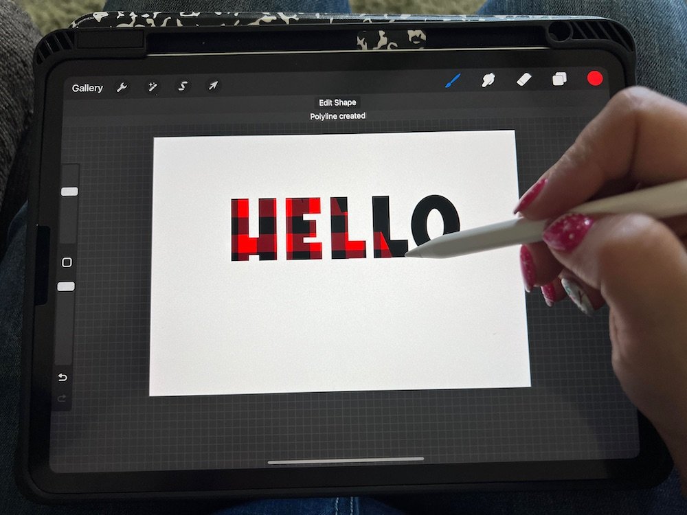 buffalo plaid procreate brush being used on an iPad to paint in the word "Hello"