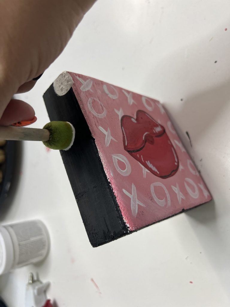 Tamara using a sponge pouncer to add dots to the sides of a wood block