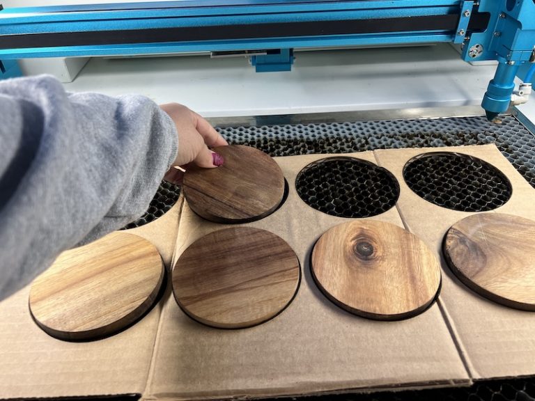 Coasters being placed in a cardboard jig