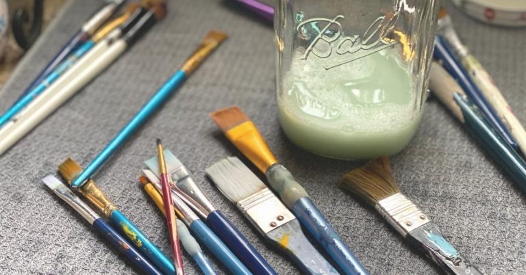 Paint Brushes next to a mason jar of cleaner