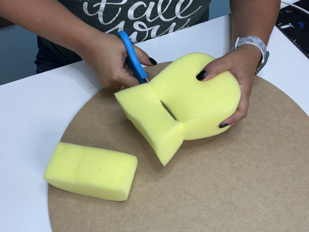 cutting a large sponge with scissors