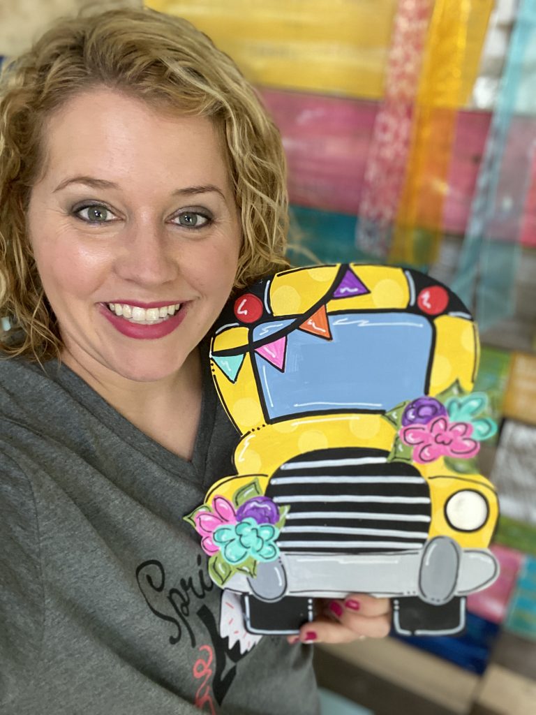 Tamara holding a floral school bus door hanger