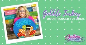 Tamara holding the Gobble Turkey door hanger on a polka dot background