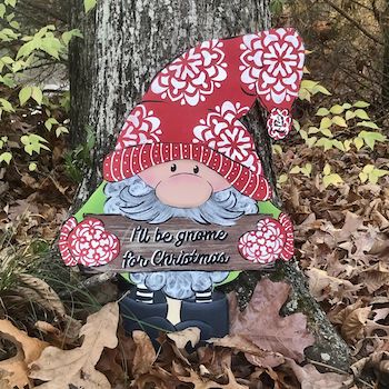 Gnome with red hat and holding a sign that says "I'll be gnome for christmas"