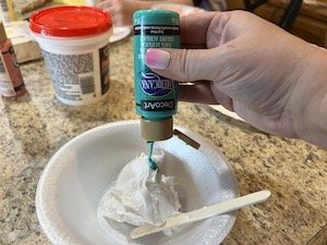 teal paint being mixed in a bowl with spackling