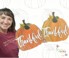 Beth Eaton holding two pumpkins that say thankful